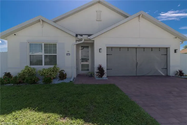 Ranch-style home with stucco siding, driveway, a front lawn, and an attached garage