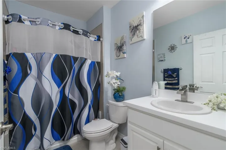Full bath featuring vanity, curtained shower, and tile patterned floors