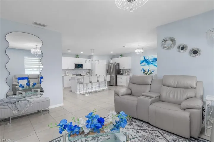 Living room featuring a chandelier, light tile patterned flooring, and recessed lighting
