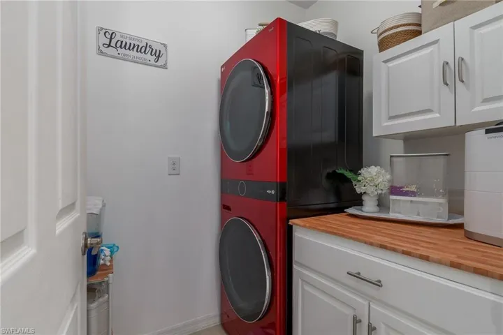 Washroom featuring cabinet space and stacked washer and clothes dryer