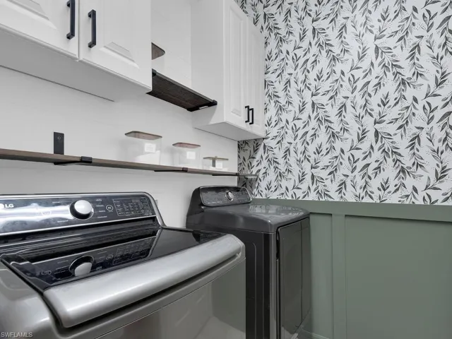 Laundry room with cabinet space and washer and clothes dryer