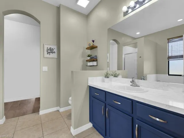 Bathroom with vanity, a shower with door, and tile patterned flooring