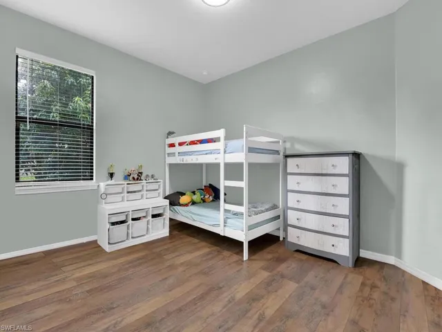 Bedroom with hardwood / wood-style floors and baseboards