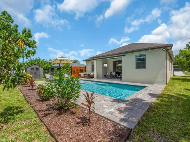 View of pool with a storage shed, a patio, a ceiling fan, and outdoor dining area