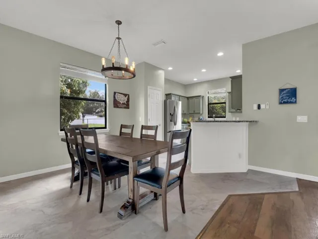 Dining area with a chandelier, healthy amount of natural light, and recessed lighting
