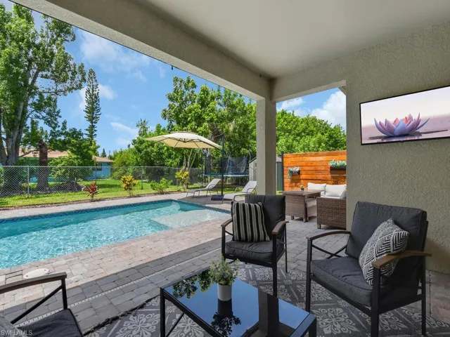 View of pool featuring a patio, a fenced backyard, an outdoor hangout area, and a trampoline