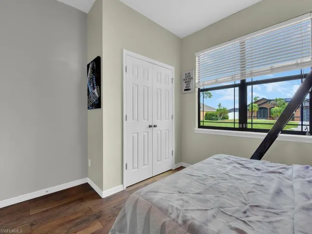 Bedroom with wood finished floors and a closet