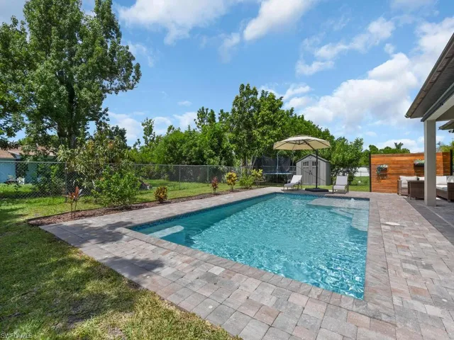 View of pool with a storage shed, a patio, an outdoor hangout area, and a fenced backyard