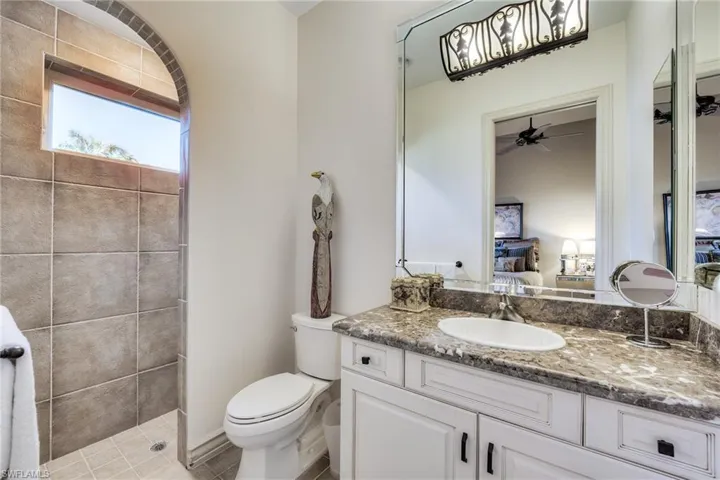 Bathroom with vanity, toilet, and a tile shower
