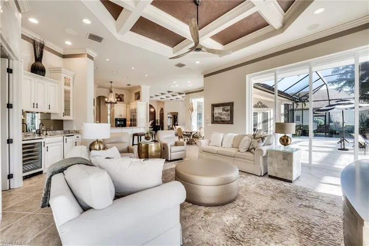 Living room with coffered ceiling, a healthy amount of sunlight, and beverage cooler