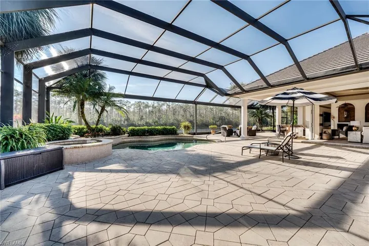 View of pool featuring a lanai, a patio area, ceiling fan, and an in ground hot tub