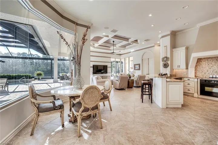 Tiled dining area featuring coffered ceiling, beam ceiling, plenty of natural light, and crown molding