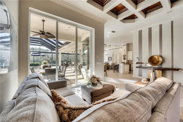 Living room featuring crown molding, ceiling fan, coffered ceiling, and beamed ceiling