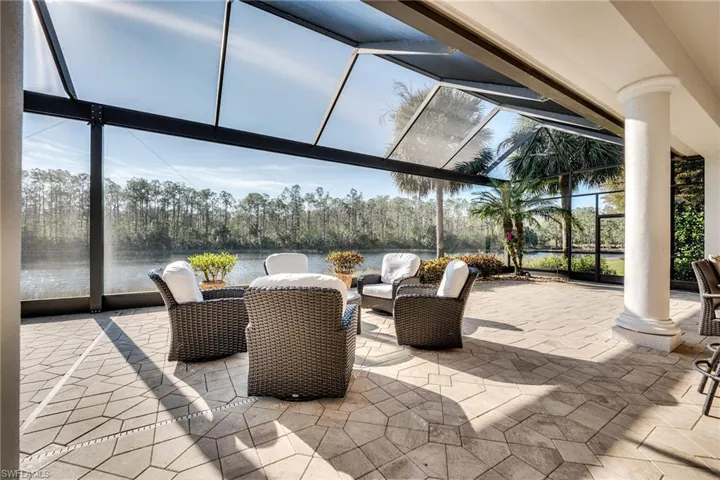 View of patio / terrace featuring a water view and glass enclosure