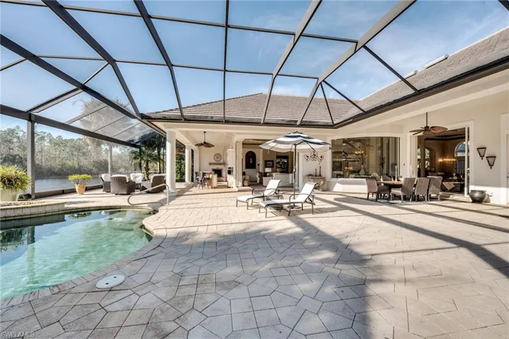 View of swimming pool with ceiling fan, a lanai, and a patio
