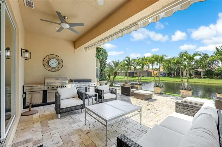 View of patio / terrace featuring outdoor lounge area, an outdoor kitchen, a water view, and a ceiling fan