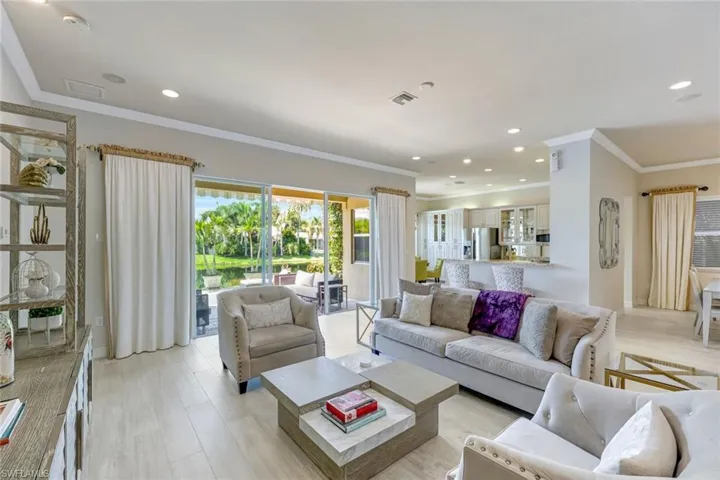 Living room with light wood-style flooring, crown molding, and recessed lighting