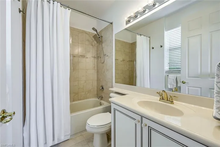 Bathroom with vanity, shower / tub combo, and light tile patterned floors
