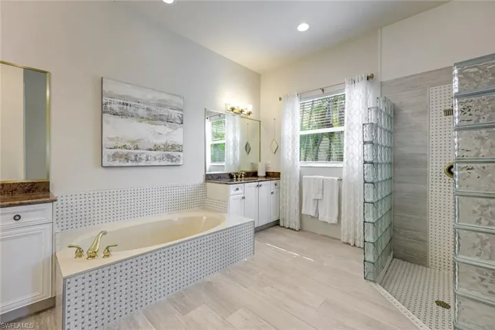 Full bath with a bath, vanity, a shower stall, light wood finished floors, and recessed lighting