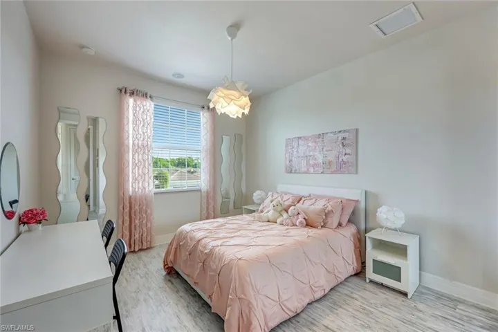 Bedroom with light wood-style flooring and baseboards