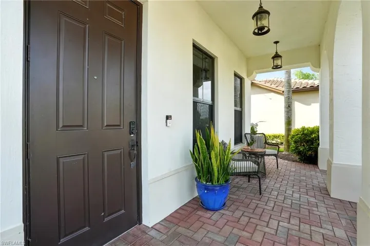 View of exterior entry featuring stucco siding and a porch