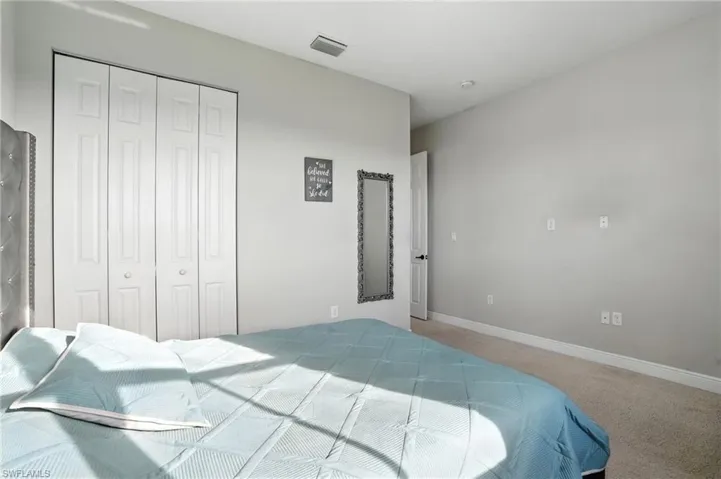 Carpeted bedroom featuring baseboards and a closet