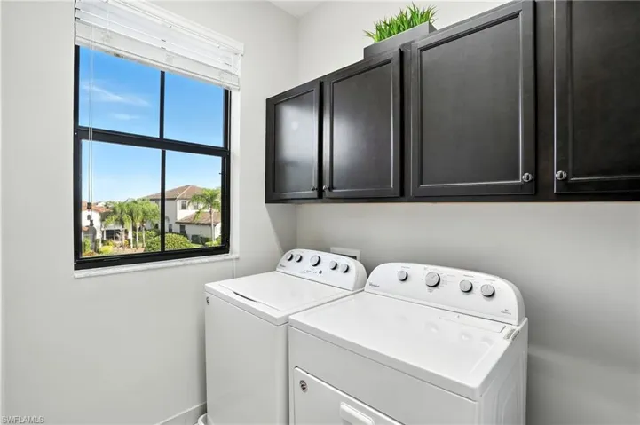 Laundry room featuring independent washer and dryer and cabinet space
