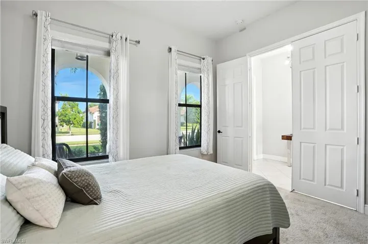 Bedroom with light colored carpet and baseboards