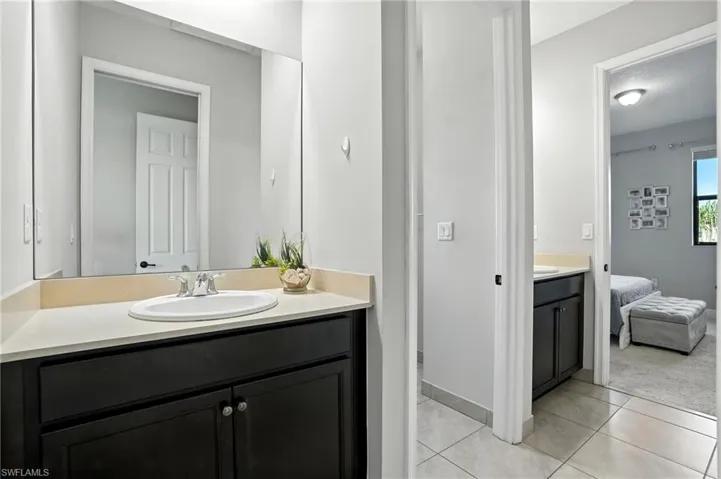 Ensuite bathroom with vanity and light tile patterned flooring