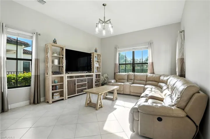 Living area with light tile patterned flooring and a chandelier