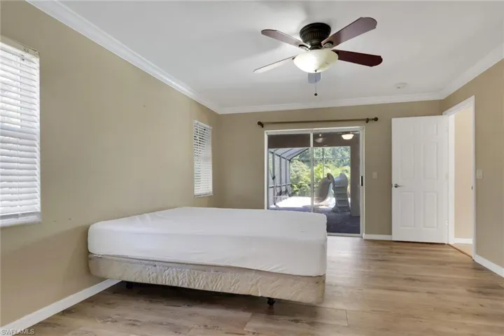 Bedroom with light wood-type flooring, access to outside, crown molding, and ceiling fan