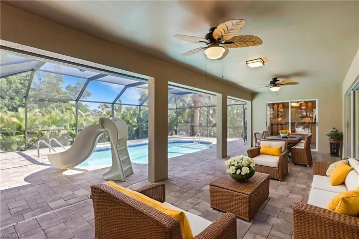 Outdoor pool with a sunroom, a lanai, a patio area, and an outdoor living / dining area
