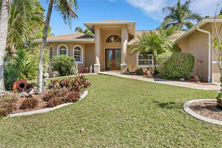 Mediterranean / spanish-style house featuring french doors, a front yard, stucco siding, and roof with shingles