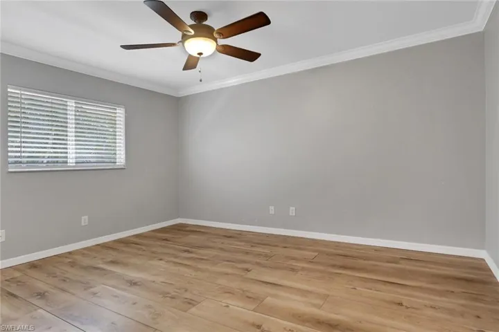 Spare room featuring ornamental molding, light wood finished floors, and ceiling fan