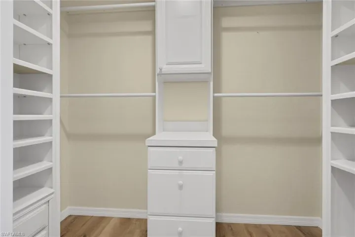 Walk in closet with light wood-type flooring
