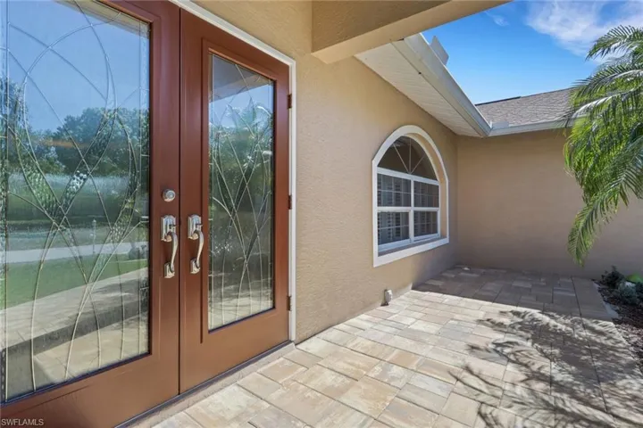 Doorway to property featuring french doors, a patio area, and stucco siding
