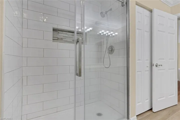 Bathroom featuring a shower stall and a closet