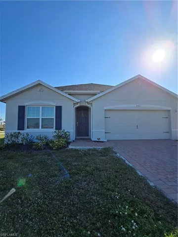 Single story home featuring a garage and a front lawn