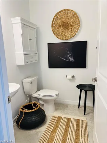 Bathroom featuring sink, tile flooring, and toilet