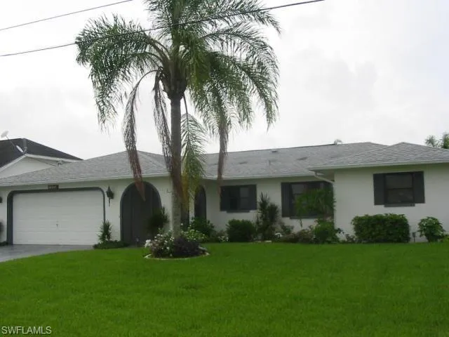 Ranch-style home featuring a garage and a front yard
