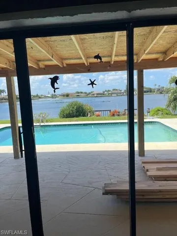 View of swimming pool featuring a water view and a patio area