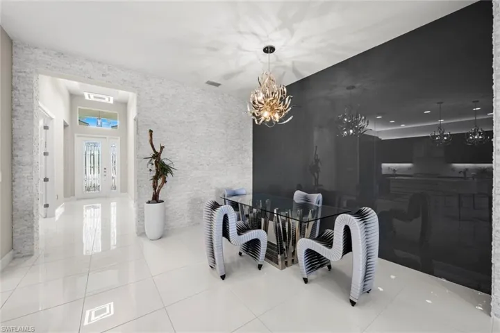 Dining space featuring an inviting chandelier, tile patterned floors, and visible vents