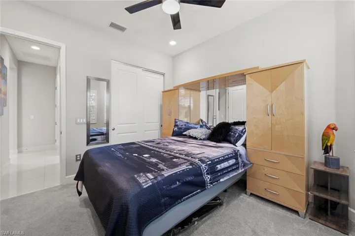 Carpeted bedroom featuring recessed lighting, baseboards, visible vents, a ceiling fan, and a closet
