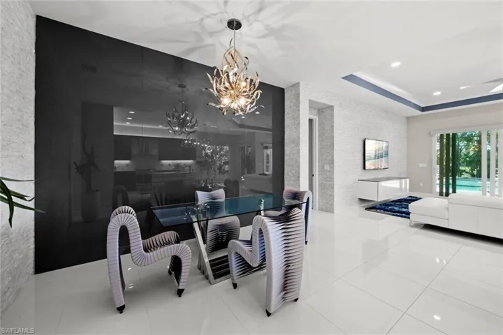 Tiled dining room featuring visible vents, a raised ceiling, recessed lighting, and a chandelier