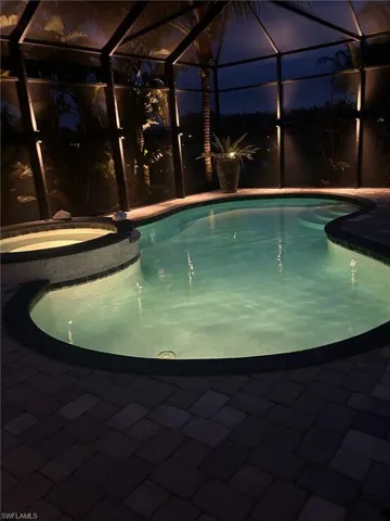 View of pool featuring a pool with connected hot tub, a lanai, and a patio area