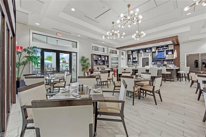 Dining room featuring a notable chandelier, wood finished floors, recessed lighting, and a raised ceiling