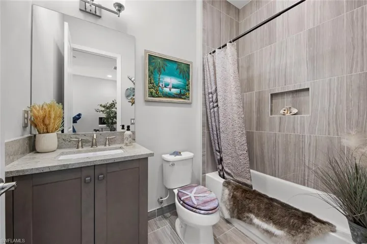 Full bath with toilet, shower / tub combo with curtain, and vanity