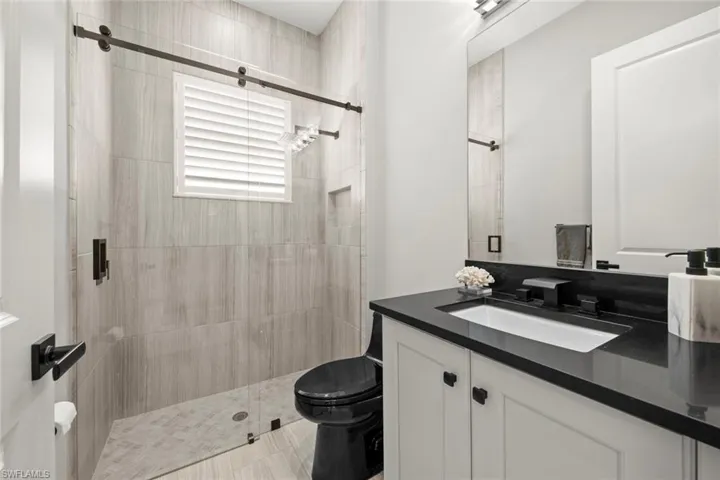 Bathroom with vanity, toilet, and a shower stall