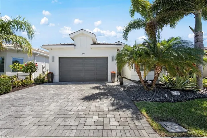 View of front of home with a tile roof, stucco siding, decorative driveway, and a garage