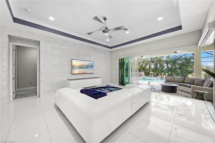 Bedroom featuring a tray ceiling, light tile patterned floors, and access to outside